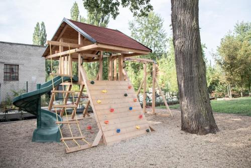 a wooden playground with a wooden play structure at Penzion Lesni in Milovice
