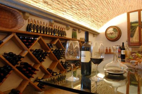 a wine cellar with two glasses and wine bottles at Corte In Fiore in Ardea