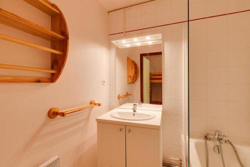 a white bathroom with a sink and a shower at Vacancéole - Résidence Saint Christophe in Les Deux Alpes
