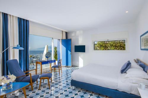 une chambre d'hôtel avec un lit, une table et des chaises dans l'établissement Parco dei Principi, à Sorrente