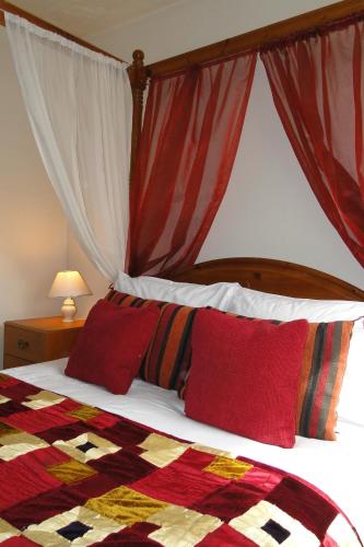 a bedroom with a bed with red pillows at Windsor Hotel in Blackpool
