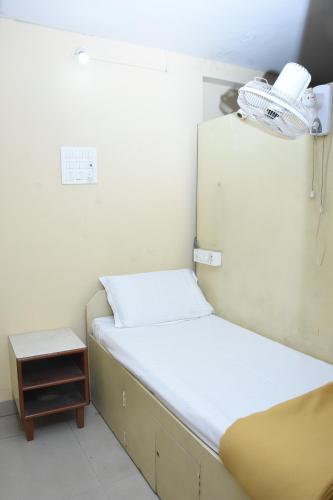 a small room with two beds and a night stand at Hotel Surya Residency Majestic in Bengaluru