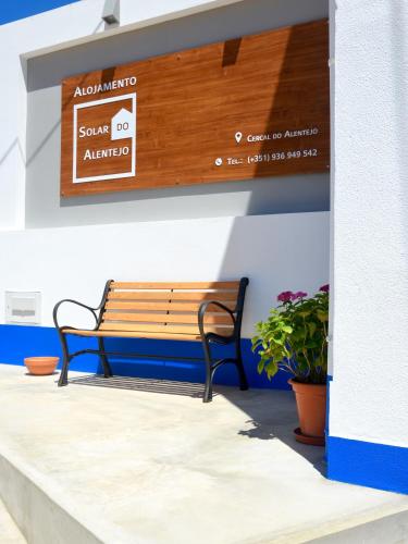 a bench sitting under a sign on a wall at Solar do Alentejo in Cercal
