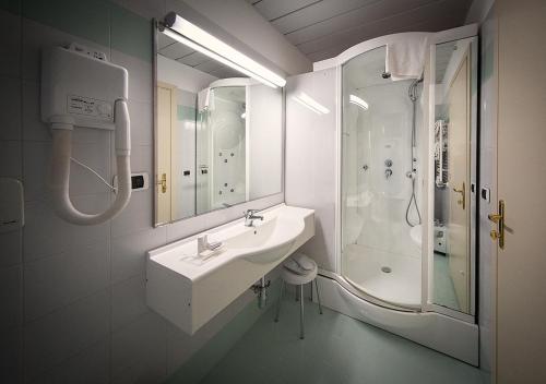 a bathroom with a shower, sink, and mirror at Hotel Ovidius in Sulmona