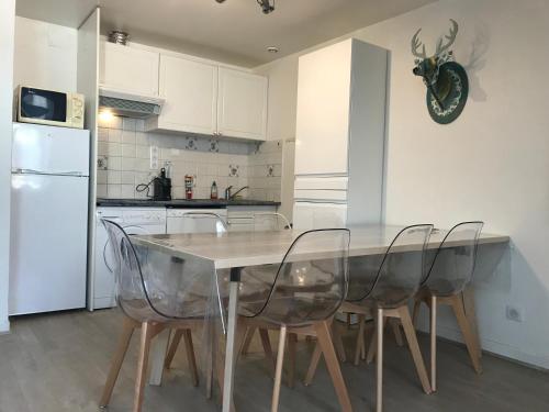 une cuisine avec une table avec des chaises et un réfrigérateur dans l'établissement Au pied du télécabine, T3 50m2 pour 8 personnes., à Cauterets
