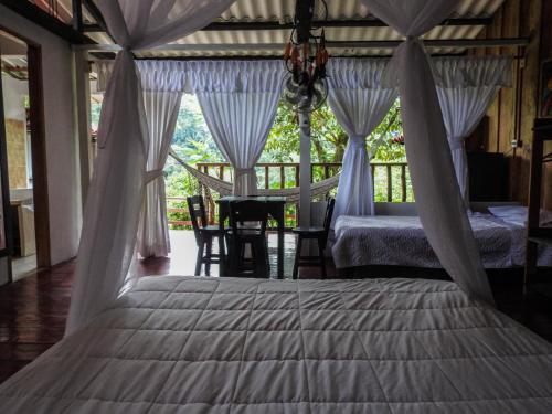 a bedroom with a bed and a table with chairs at Posada Turistica Dantayaco in Mocoa