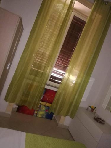 a bathroom with a window with green curtains and a tub at B&B IL POETA in Palermo