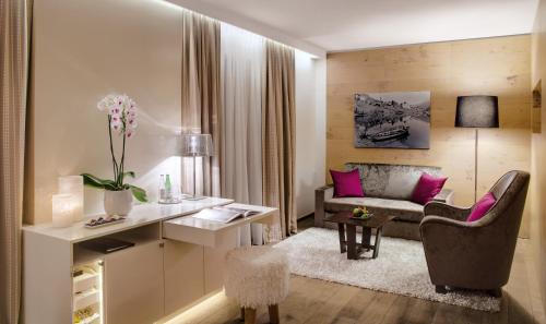 a living room with a desk and a couch at Giardino Mountain in St. Moritz