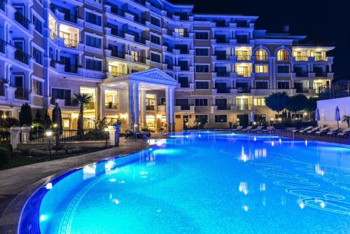 a swimming pool in front of a building at night at VILLA FLORENCE Boutique Apart Hotel in Sveti Vlas