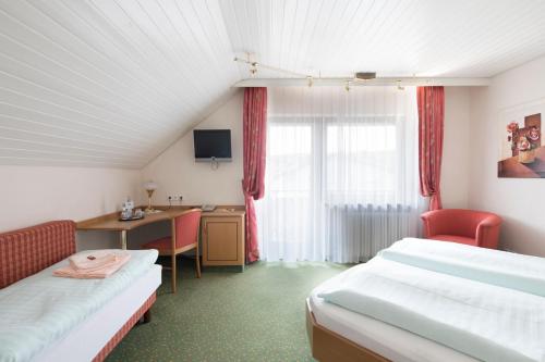 a hotel room with two beds and a desk with a computer at Hotel Riegeler Hof in Riegel