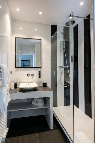 a bathroom with a sink and a shower at Hotel Arok in Strasbourg