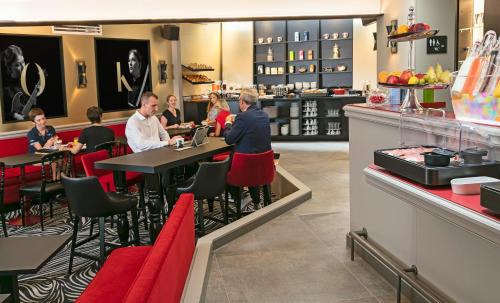 a group of people sitting at tables in a restaurant at Hotel Arok in Strasbourg