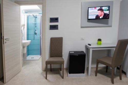 a bathroom with a table and a tv on the wall at La Tonnara B&B in Palmi