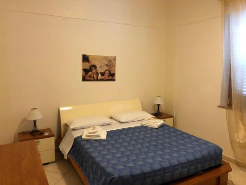 a bedroom with a bed with a blue comforter at La Marinella in Palmi