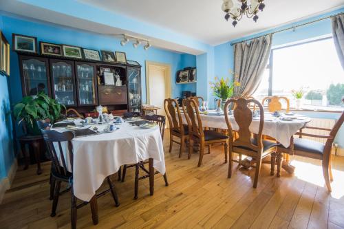 una sala da pranzo con tavoli, sedie e una grande finestra di Castle View House a Ballylongford