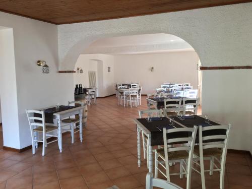 a dining room with tables and white chairs at Albergo Ristorante Belcantone in Novaggio