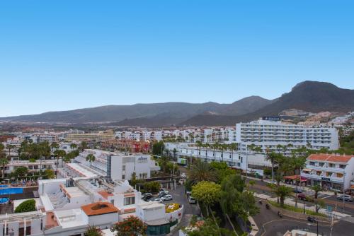 a city with buildings and mountains in the background at Iberostar Waves Bouganville Playa in Adeje