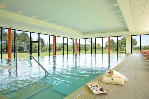 a large pool with water in a building with windows at See Park Janssen in Geldern