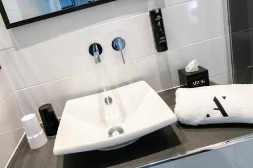 a bathroom sink with a faucet on a counter at Hotel Arok in Strasbourg
