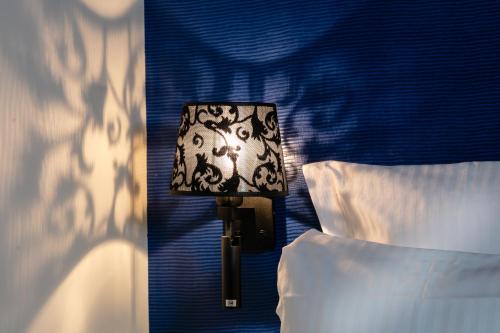 a lamp in a bedroom next to two beds at Hotel Arok in Strasbourg