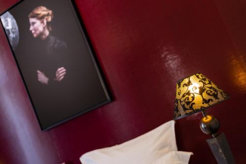 a lamp in a room with a picture on the wall at Hotel Arok in Strasbourg