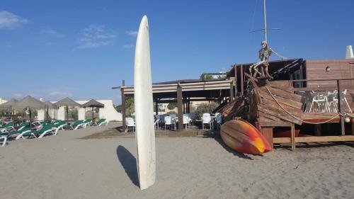 a surfboard on the beach next to a building at Apartment zona Naturista in Vera