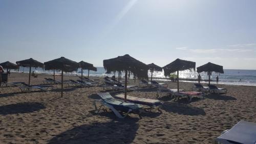 a beach with chairs and umbrellas and the ocean at Apartment zona Naturista in Vera