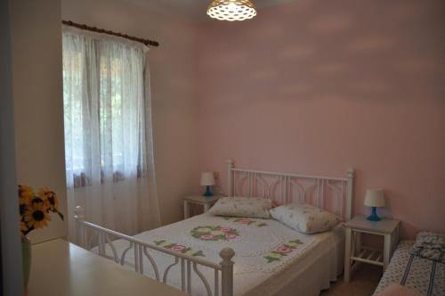 a bedroom with a bed and a window at Areti's Apartment in Agios Georgios Pagon