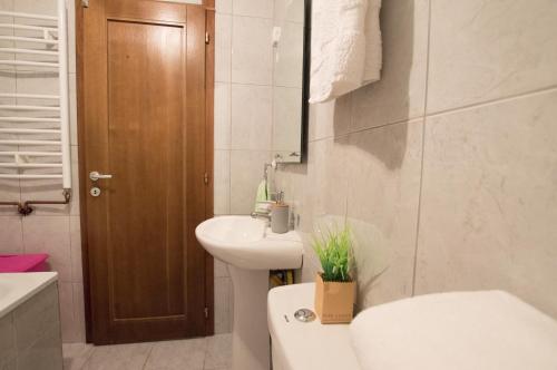 a white bathroom with a sink and a toilet at Apartment Holiday in Kolašin