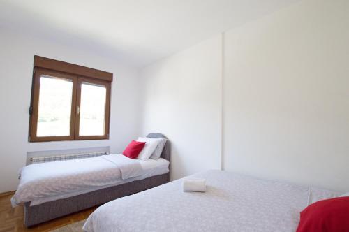 1 Schlafzimmer mit 2 Betten und einem Fenster in der Unterkunft Apartment Holiday in Kolašin