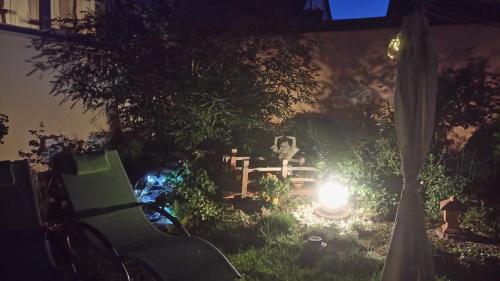 a garden at night with a bench and a candle at ApartmentHotel Vollumen in Redwitz an der Rodach