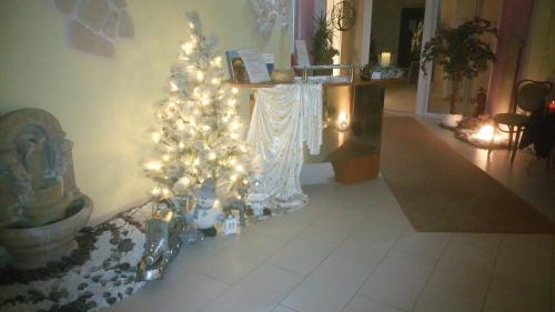 a christmas tree with lights in a living room at ApartmentHotel Vollumen in Redwitz an der Rodach