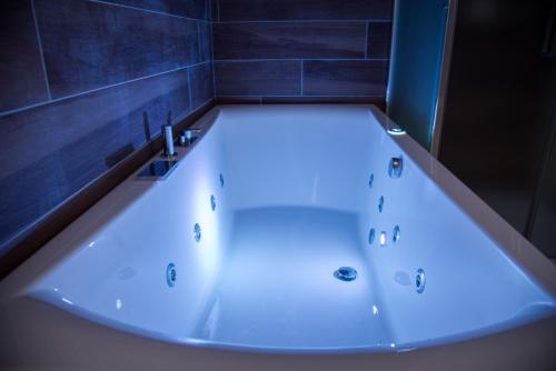 a white tub in a bathroom with blue tiles at La dimora del barone in Salerno