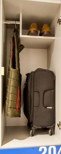 a closet with a bag and a suitcase at izZzleep Aeropuerto Terminal 2 in Mexico City