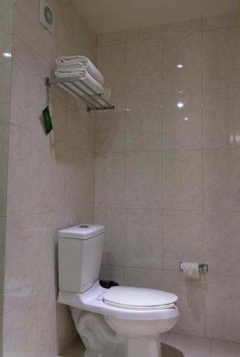 a bathroom with a white toilet in a room at Hotel Aeropuerto Los Cabos in San José del Cabo
