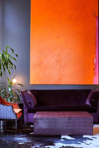 a living room with a black couch and an orange painting at Hotel St Paul, Montreal, a Member of Design Hotels in Montréal