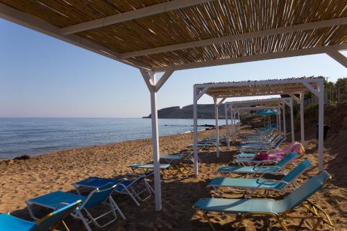 a row of lounge chairs on the beach at Rethymno Mare Royal & Water Park in Skaleta