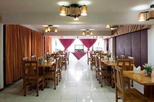 une salle à manger avec des tables et des chaises en bois dans l'établissement Hotel Samaña, à Arica