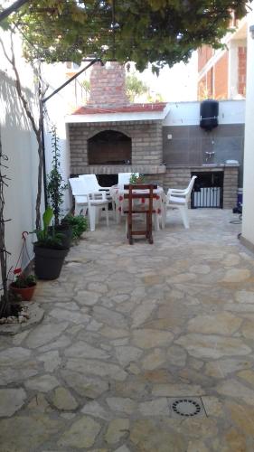 een patio met een tafel en stoelen en een open haard bij Apartmani Svalina - Seaview and 130m from Beach in Trogir