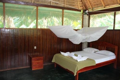a bedroom with a bed with a net above it at Paradise Amazon Tambopata Ecolodge in Puerto Maldonado