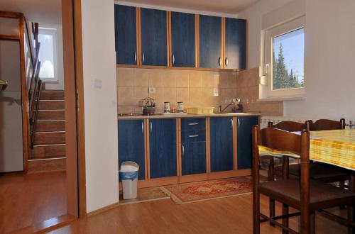 a kitchen with blue cabinets and a table with chairs at Apartment Jovana in Kopaonik