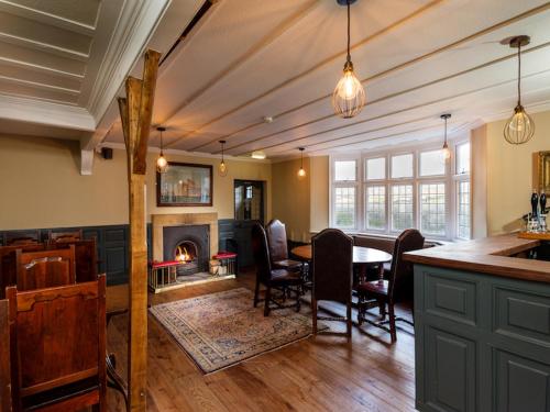 a dining room with a table and a fireplace at The Wheatsheaf at Beetham in Sandside