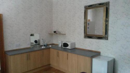a bathroom with a sink and a mirror at Station View Guest House in Dyce