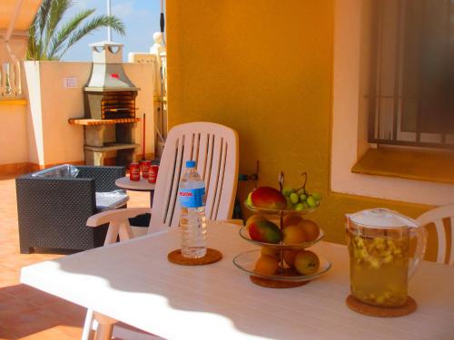 阿雷納萊斯德索的住宿－Arenales del Sol，一张桌子,上面有一瓶水和水果