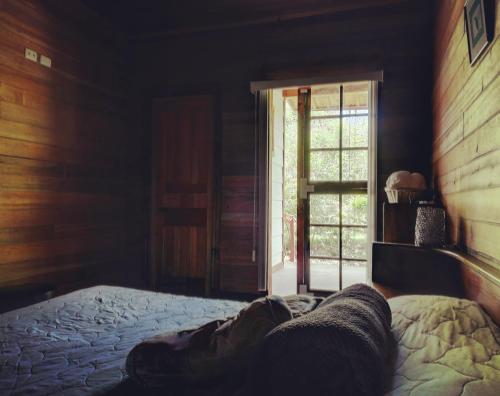 a bedroom with a bed and a sliding glass door at Finca Queveri in Orosí