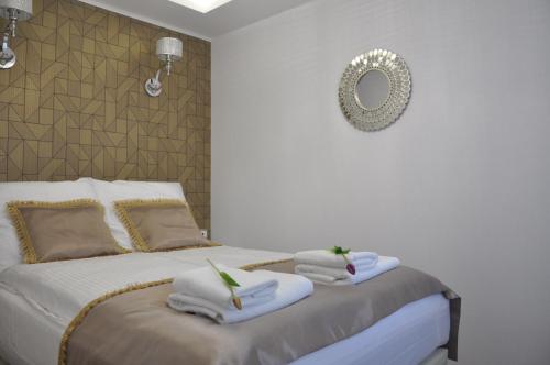 a bedroom with two beds with towels and a mirror at Golden Apartments - City Centrum in Białystok