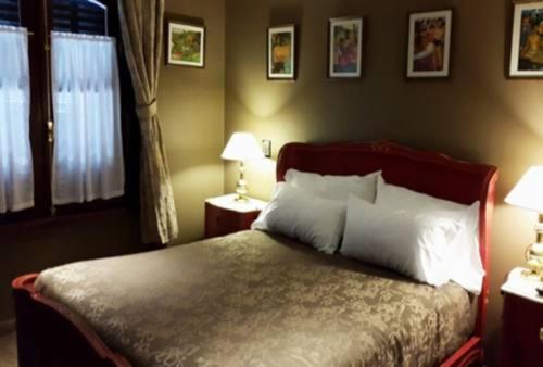 a bedroom with a bed with two lamps and two tables at Hotel City Bell in La Plata
