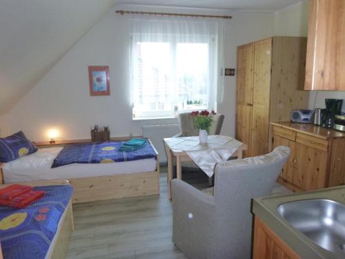 a small room with a bed and a table and a bed and a kitchen at Feriendomizil SONNE , SAND & MEER in Zinnowitz