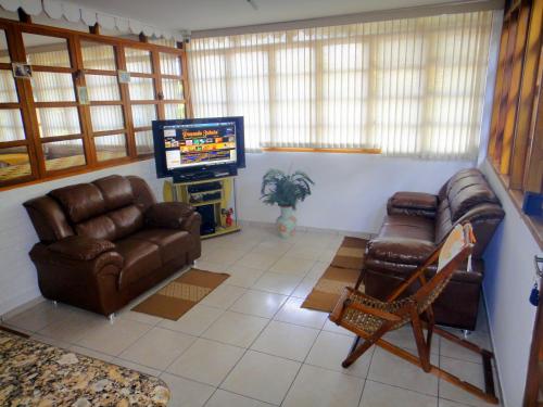 a living room with couches and a flat screen tv at Pousada Jubaia in Bonito