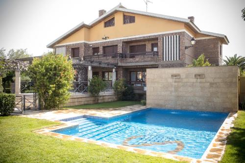 una casa con piscina frente a una casa en Finca Lebrel, en Pedrola